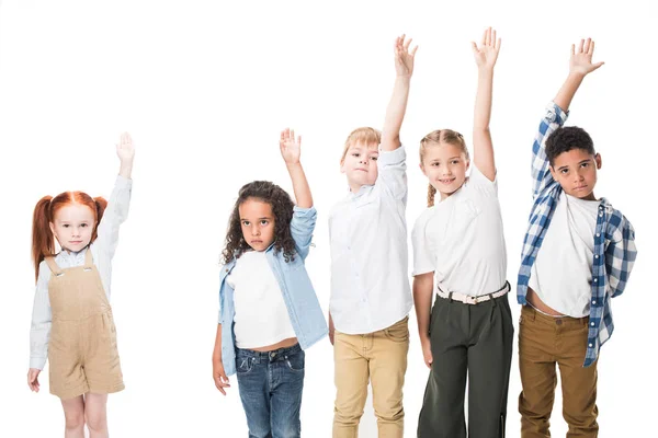 Niños multiétnicos levantando manos - foto de stock