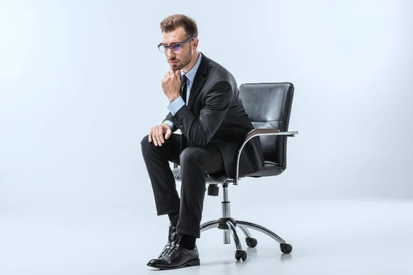 Hombre de negocios pensativo sentado en la silla - foto de stock