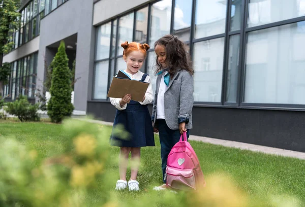 Colegialas multiétnicas cerca de la escuela - foto de stock