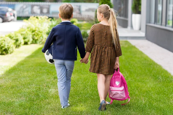 Cute schoolchildren holding hands — Stock Photo