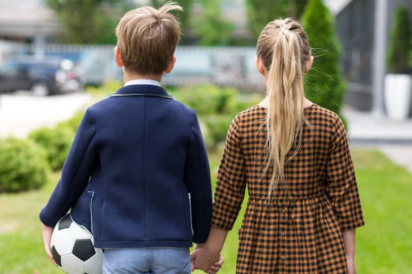 Cute schoolchildren holding hands — Stock Photo