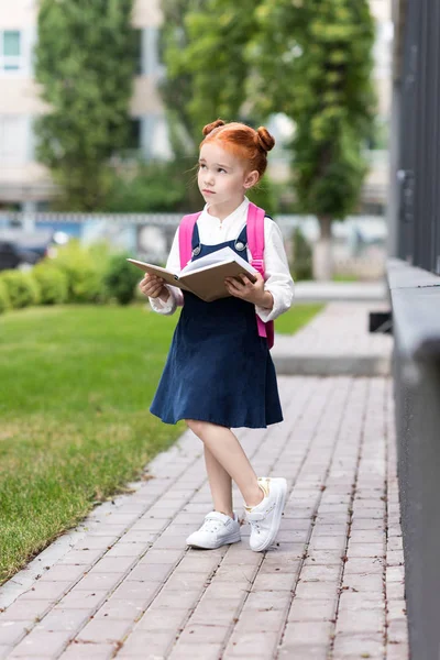 Redhead schoolgirl holding book — Stock Photo