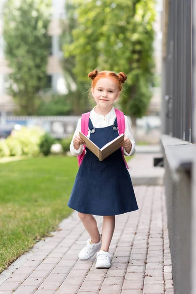 Redhead schoolgirl holding book — Stock Photo