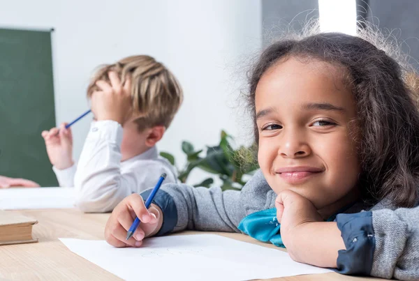 Des écoliers multiethniques dessinent en classe — Photo de stock