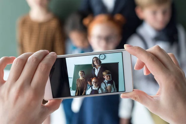 Profesor y estudiantes fotografiando con smartphone - foto de stock