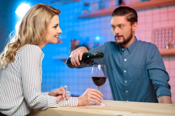 Bartender pouring wine to woman — Stock Photo