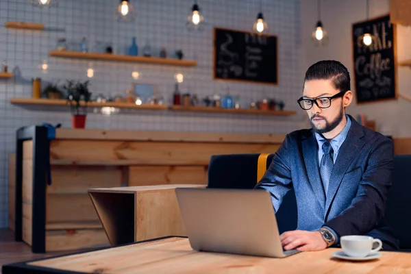 Homme d'affaires utilisant un ordinateur portable dans un café — Photo de stock