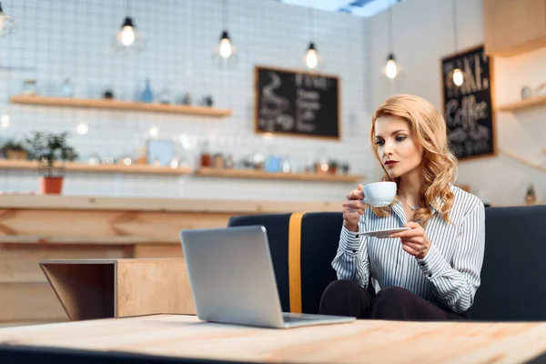 Donna d'affari che utilizza il computer portatile nel caffè — Foto stock