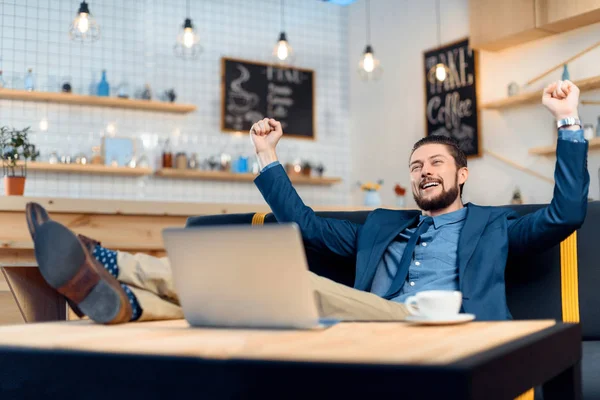 Empresario usando laptop en cafetería - foto de stock