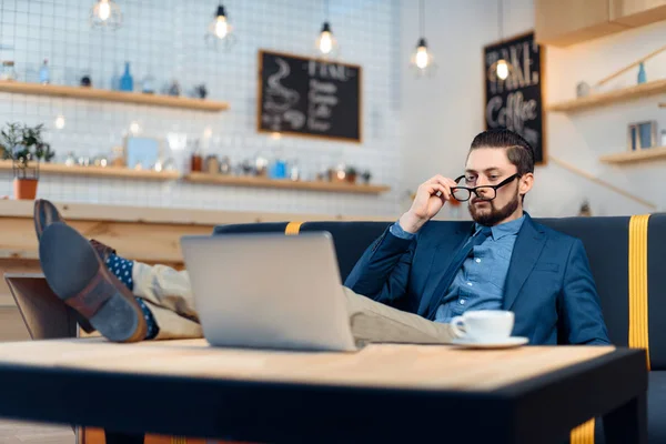 Empresário usando laptop no café — Fotografia de Stock