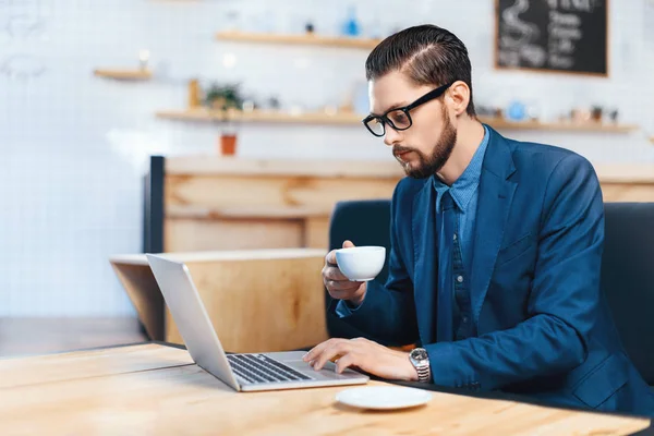 Businessman using laptop in cafe — Stock Photo