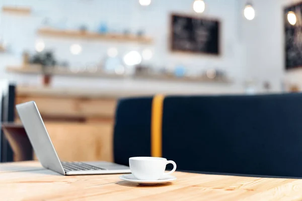 Coffee cup and laptop — Stock Photo