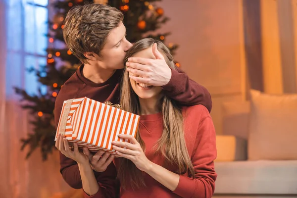 Man surprising woman with gift — Stock Photo