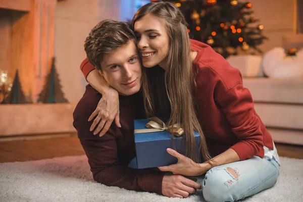 Mujer feliz abrazando novio en Navidad - foto de stock