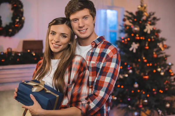 Man hugging girlfriend with christmas present — Stock Photo