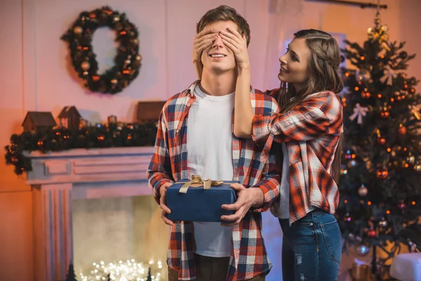Woman surprising boyfriend on christmas — Stock Photo