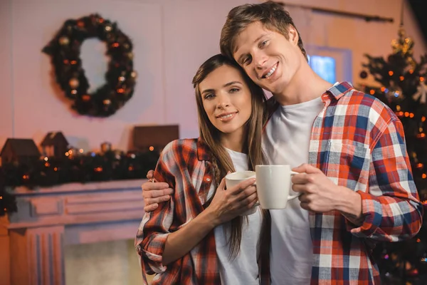 Casal com copos de bebidas quentes — Fotografia de Stock