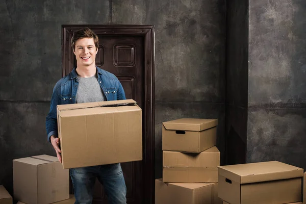 Alegre hombre moviéndose en nuevo hogar - foto de stock