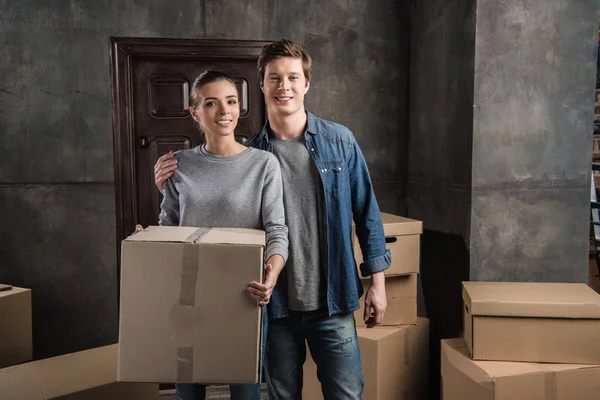 Couple with cardboard box at new home — Stock Photo