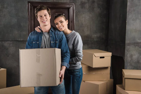 Pareja con caja de cartón en casa nueva - foto de stock