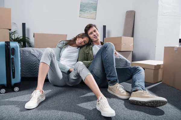Пара, сидящая на полу в новом доме — стоковое фото