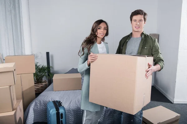 Couple portant boîte en carton à la nouvelle maison — Photo de stock