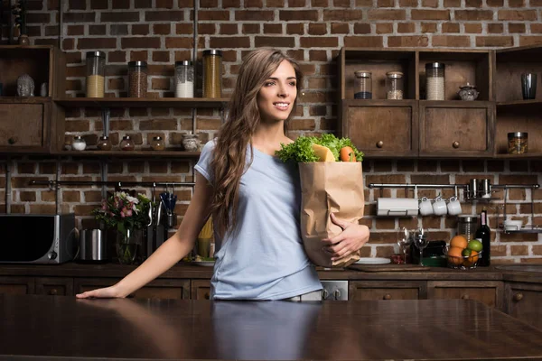 Woman with paper bag full of food — Stock Photo