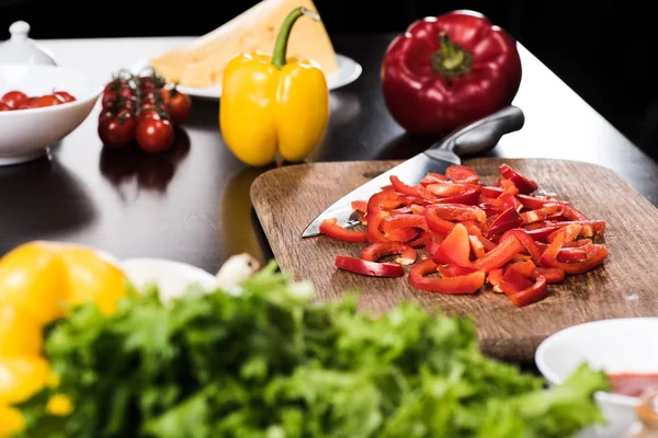 Cortar el pimiento en la tabla de cortar - foto de stock