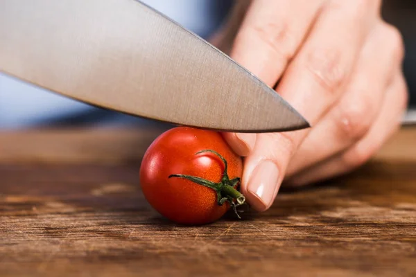 Femme coupe tomate cerise — Photo de stock