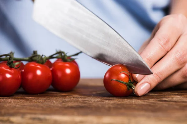 Femme coupe tomates cerises — Photo de stock