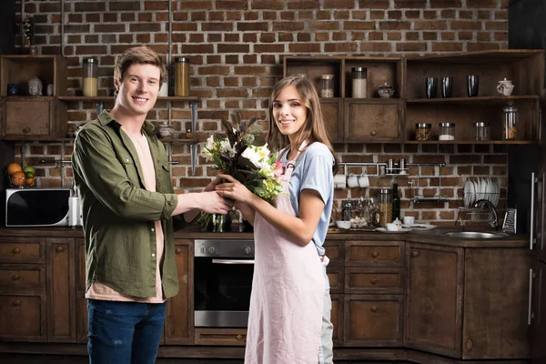 Homme présentant bouquet de fleurs à petite amie — Photo de stock