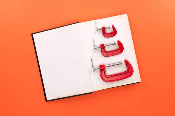 Open notebook and c-clamps — Stock Photo