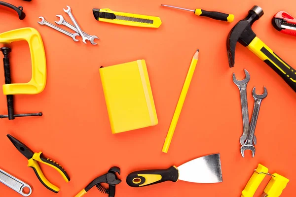 Cuaderno amarillo y herramientas de reparación — Stock Photo