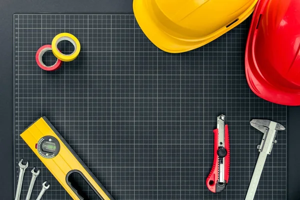 Tools and hardhats on graph paper — Stock Photo