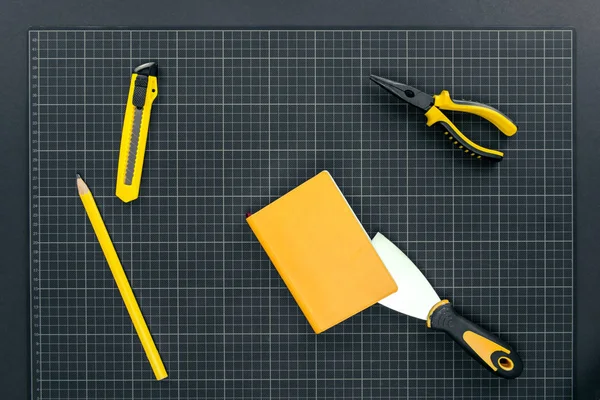 Cuaderno y herramientas en papel gráfico - foto de stock