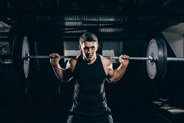 Sportsman lifting a barbell — Stock Photo