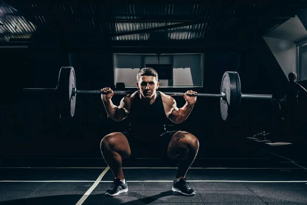 Sportsman lifting a barbell — Stock Photo