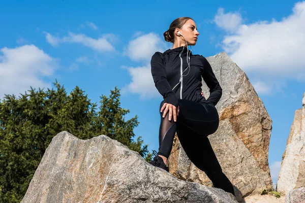 Joven mujer deportiva sobre rocas - foto de stock