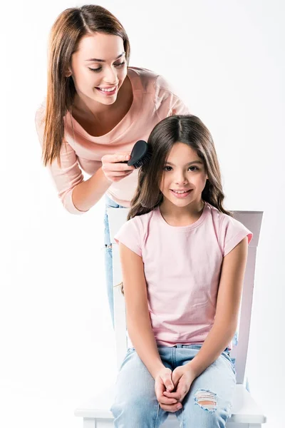 Madre peinando hijas cabello - foto de stock