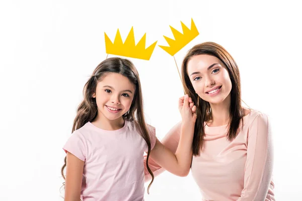 Madre e hija con coronas de papel en palo - foto de stock