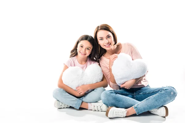 Daughter and mother with heart shaped pillows — Stock Photo
