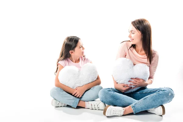 Hija y madre con almohadas en forma de corazón - foto de stock