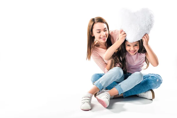 Madre e hija jugando con almohada - foto de stock