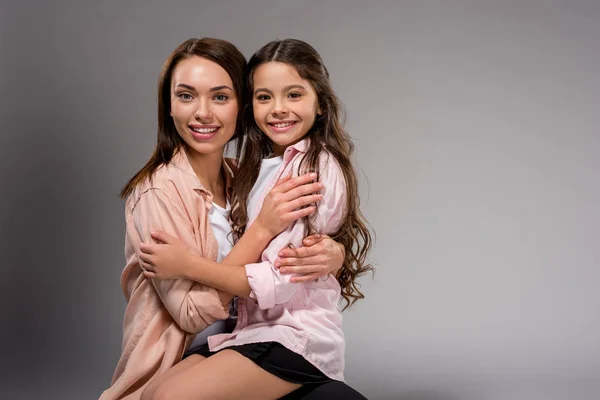 Hija sentado en madres piernas - foto de stock