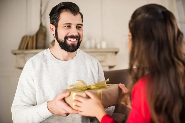 Handsome father presenting gift box to daughter — Stock Photo