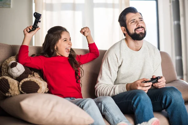 Hija gritando y ganando padre en el videojuego - foto de stock