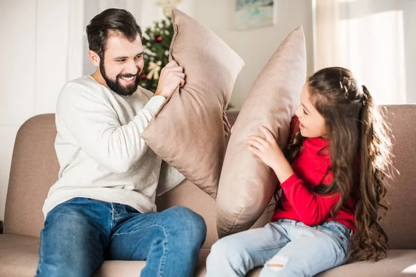 Padre e figlia felici che picchiano con cuscini a casa — Foto stock