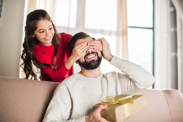 Tochter bedeckt lächelnde Augen des Vaters von hinten — Stockfoto