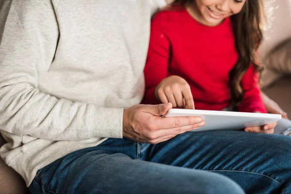 Image recadrée de fille montrant quelque chose sur tablette au père — Photo de stock