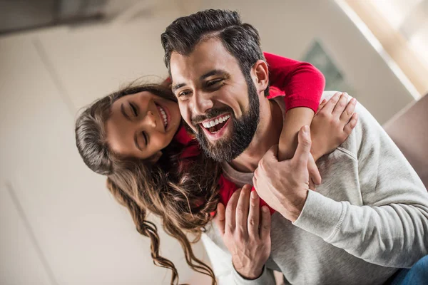 Daughter hugging happy father from back at home — Stock Photo